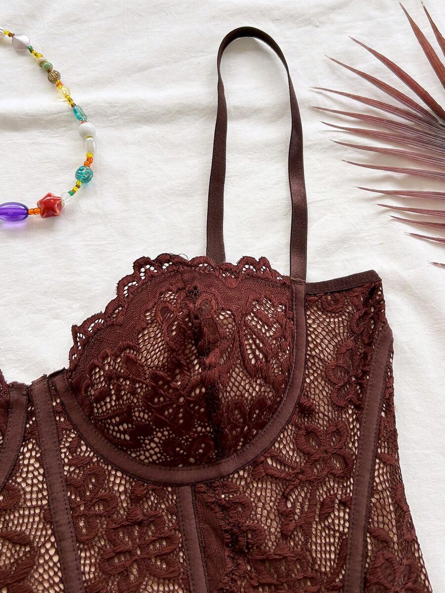 Women's lace bustier camisole top with spaghetti straps, contrast lace, lace-up detail, and an asymmetrical hem in a slim fit design.