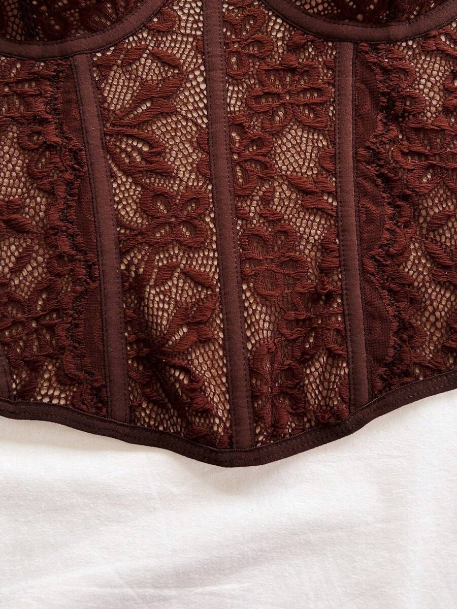 Women's lace bustier camisole top with spaghetti straps, contrast lace, lace-up detail, and an asymmetrical hem in a slim fit design.