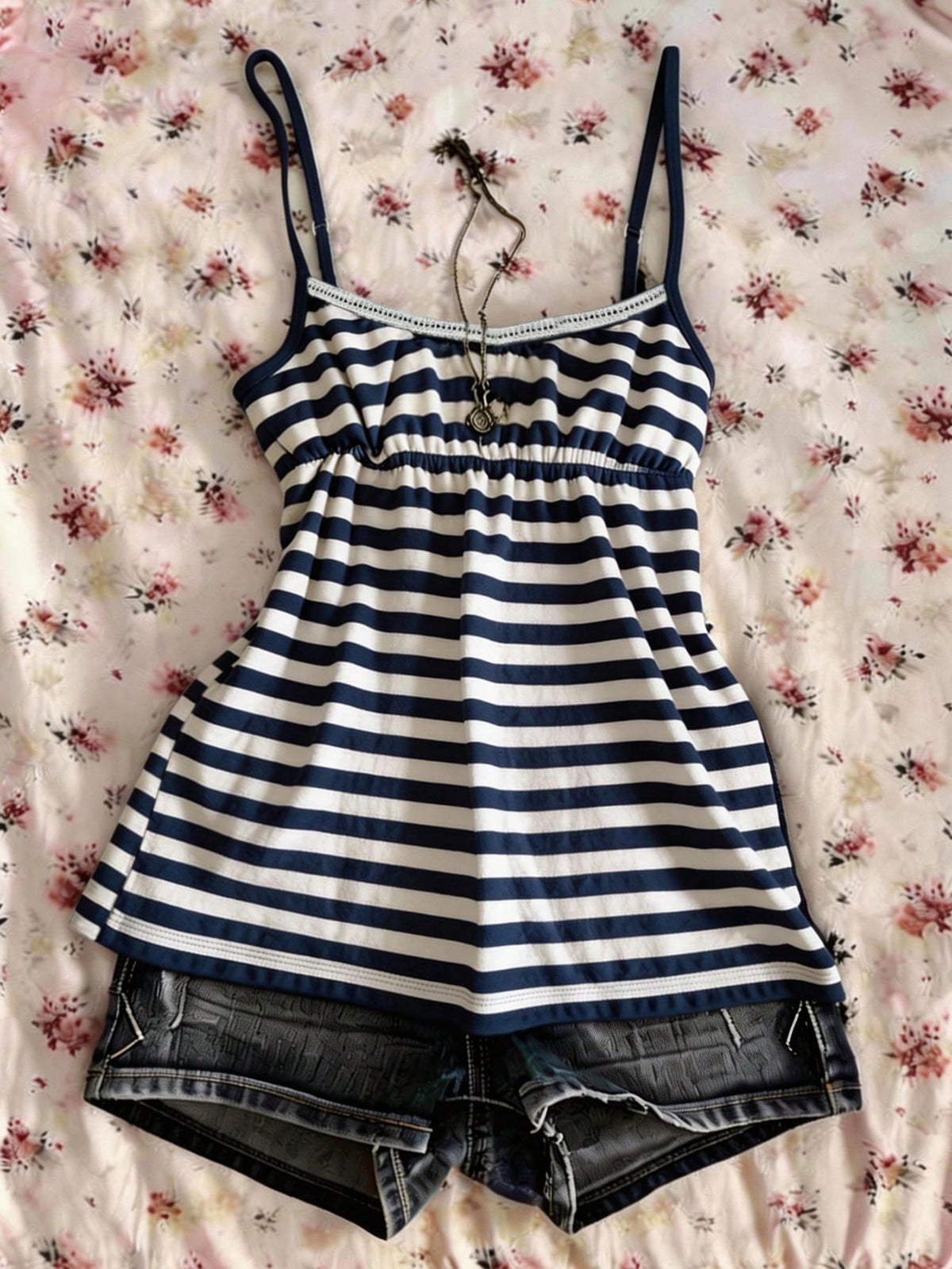 A women's black striped camisole top featuring spaghetti straps, a backless design with ring detail, and high-stretch knitted fabric.