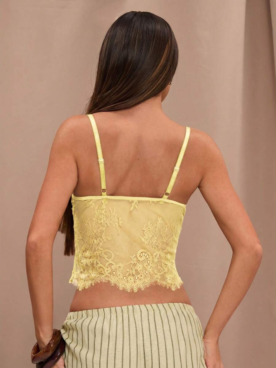 Black floral lace cropped camisole top for women featuring delicate spaghetti straps, cup detail, and semi-sheer contrast lace.
