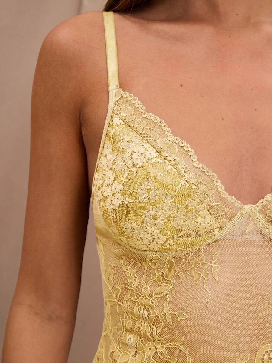 Black floral lace cropped camisole top for women featuring delicate spaghetti straps, cup detail, and semi-sheer contrast lace.