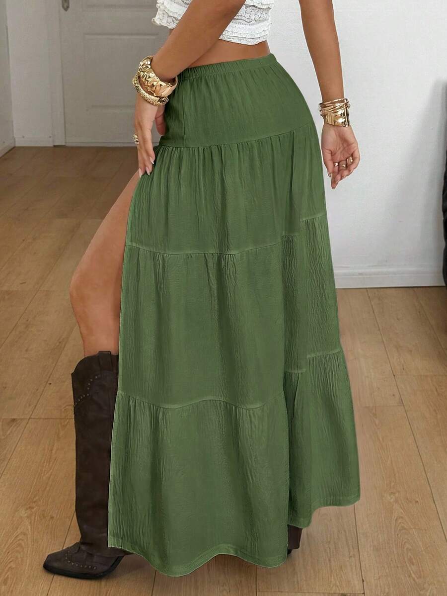 Women's black low waist split thigh long skirt featuring semi-sheer textured fabric and a flared skinny fit.