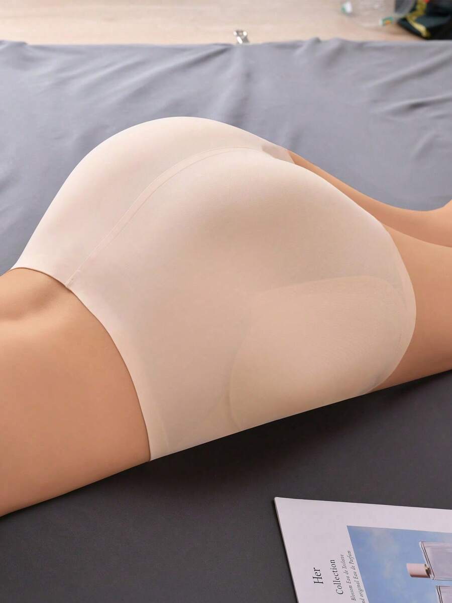 Women's high waist seamless tummy control panties with hip enhancer padding in apricot.
