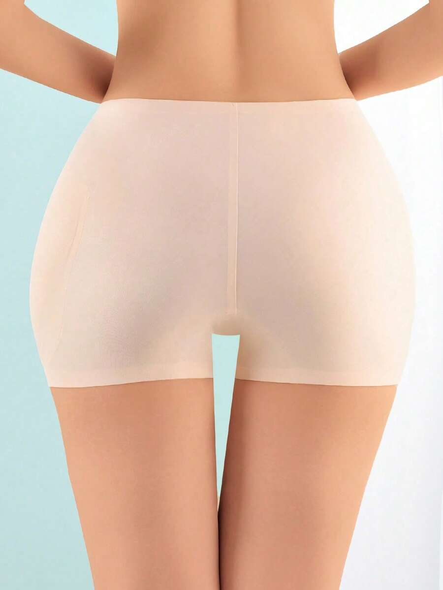 Women's high waist seamless tummy control panties with hip enhancer padding in apricot.
