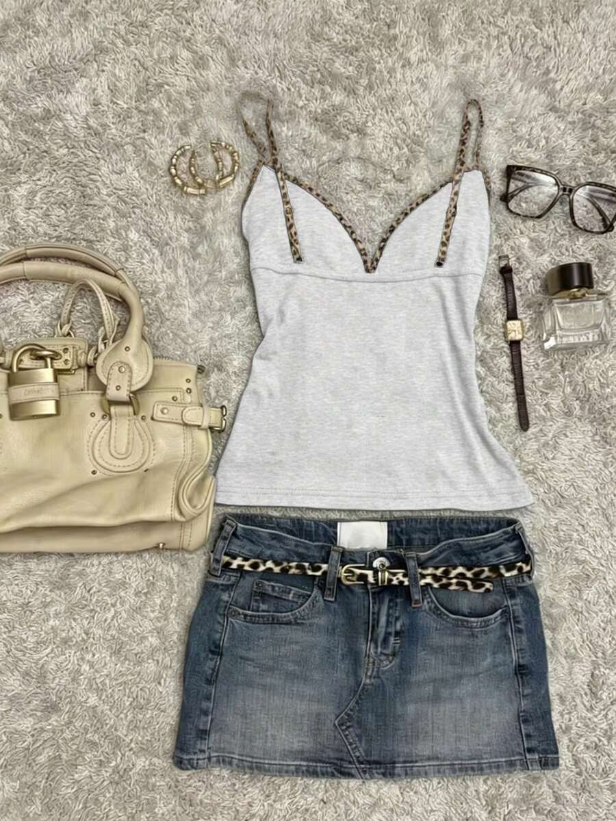 A women's solid slim fit camisole top with delicate contrast lace trim around the neckline and spaghetti straps.