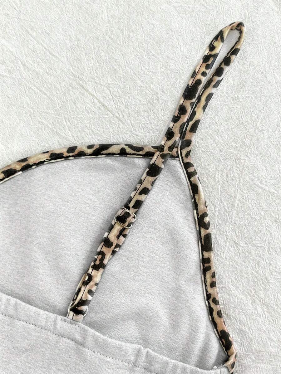 A women's solid slim fit camisole top with delicate contrast lace trim around the neckline and spaghetti straps.