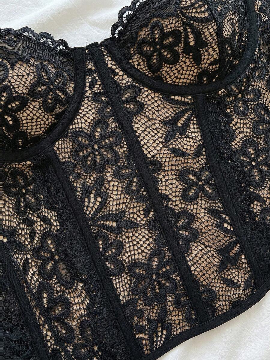 Women's lace bustier camisole top with spaghetti straps, contrast lace, lace-up detail, and an asymmetrical hem in a slim fit design.
