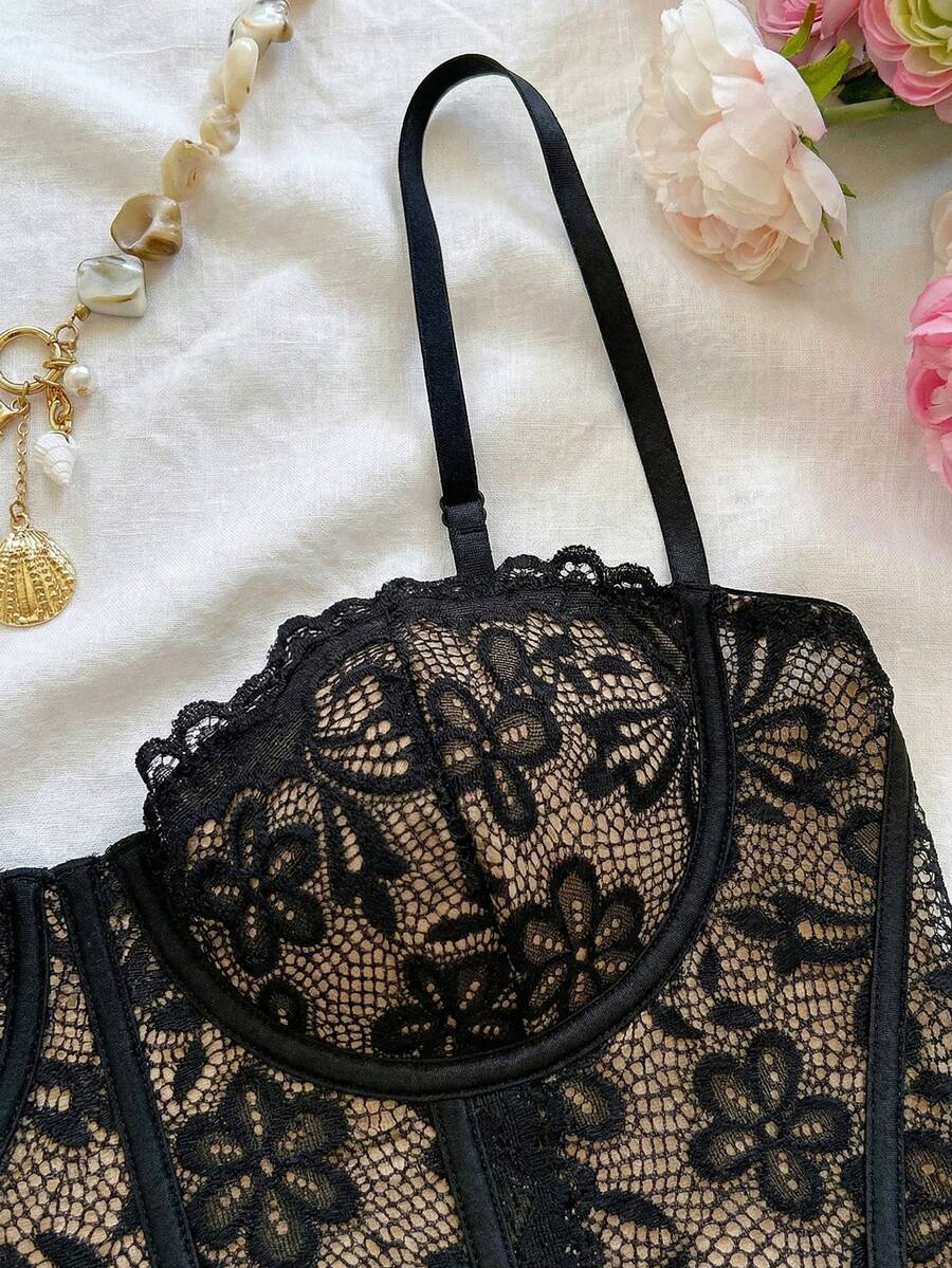Women's lace bustier camisole top with spaghetti straps, contrast lace, lace-up detail, and an asymmetrical hem in a slim fit design.
