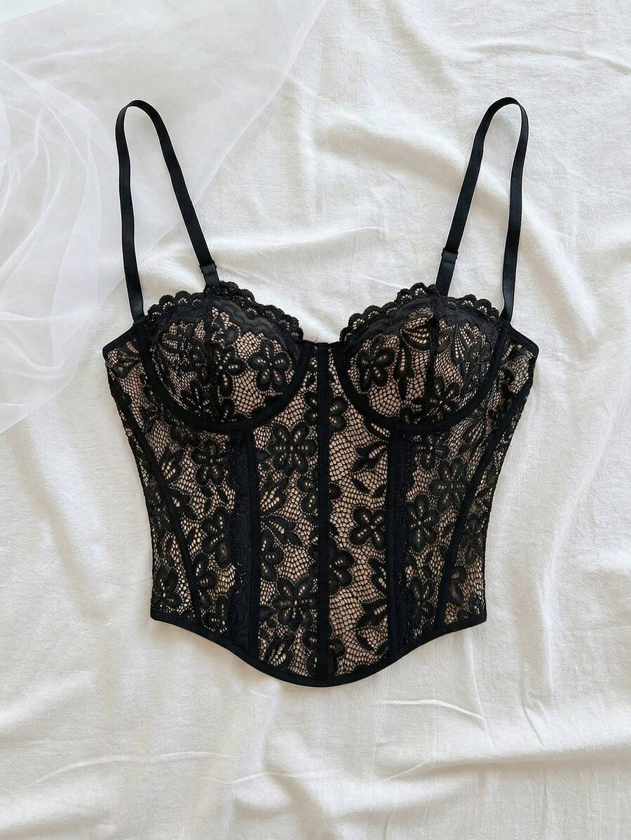 Women's lace bustier camisole top with spaghetti straps, contrast lace, lace-up detail, and an asymmetrical hem in a slim fit design.