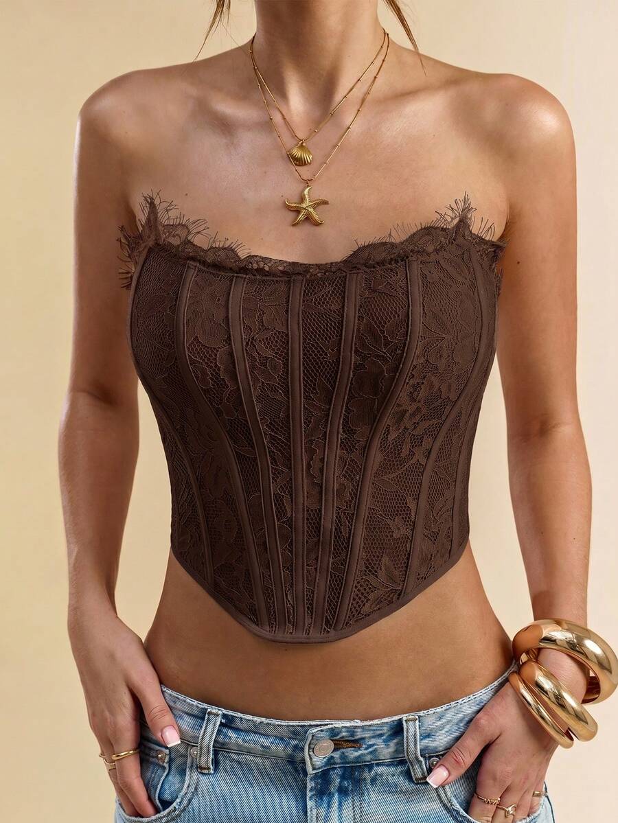 Women's strapless bustier crop top with contrast lace, lace-up detail, and an asymmetric hem in a slim-fit satin finish.