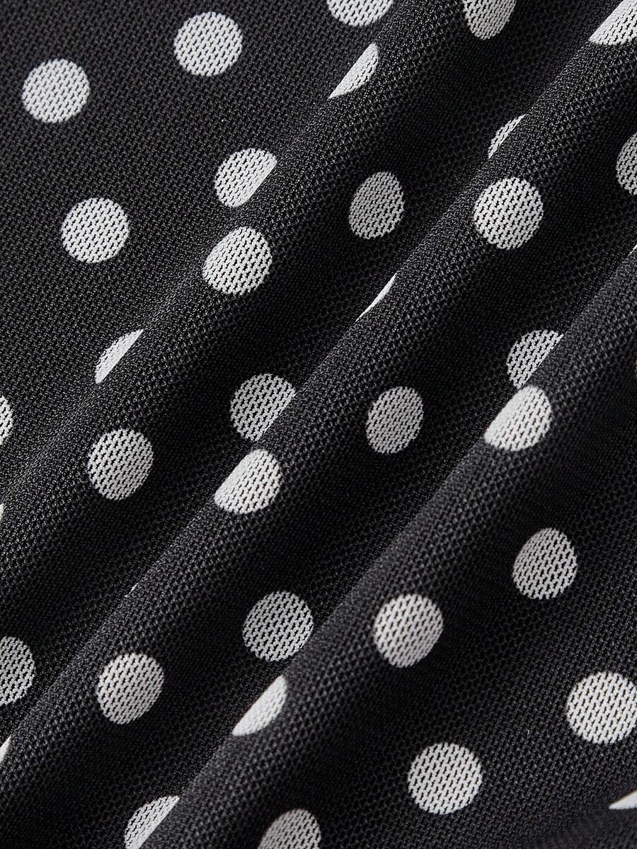 Women's black and white polka dot mesh camisole top with asymmetrical ruffle hem and square neckline.