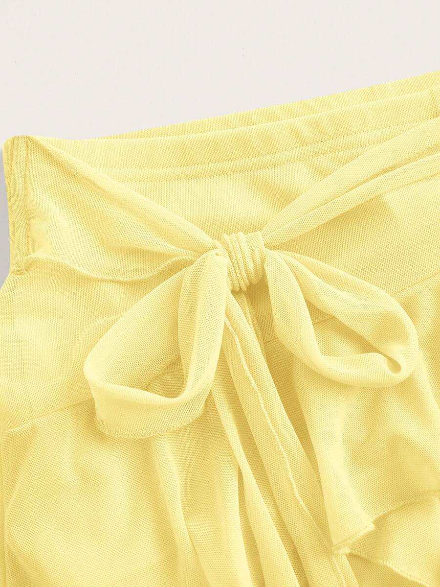 White tiered ruffle trim mini skirt for women with low waist, knot detail, mesh fabric, and casual Y2K boho design.