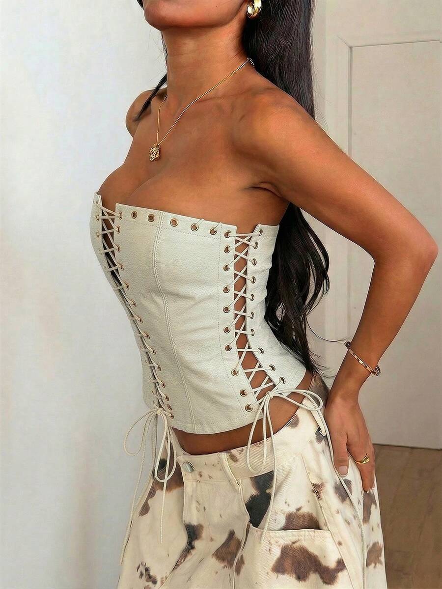 Women’s coffee brown faux leather lace-up crop top with strapless neckline, slit hem, and slim fitted silhouette for festival and nightlife wear.