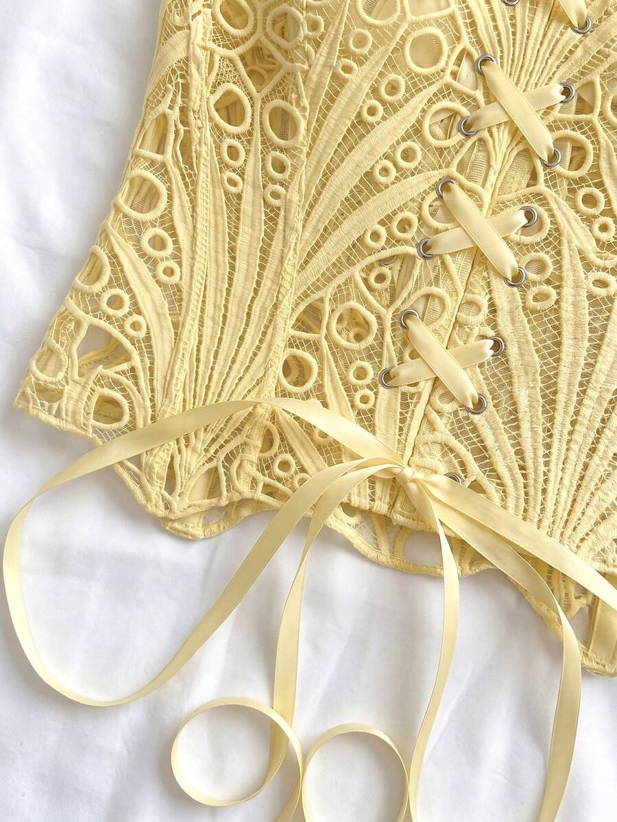 Women’s strapless corset bustier top with lace-up detail, asymmetrical embroidery, semi-sheer finish, and slim fit.