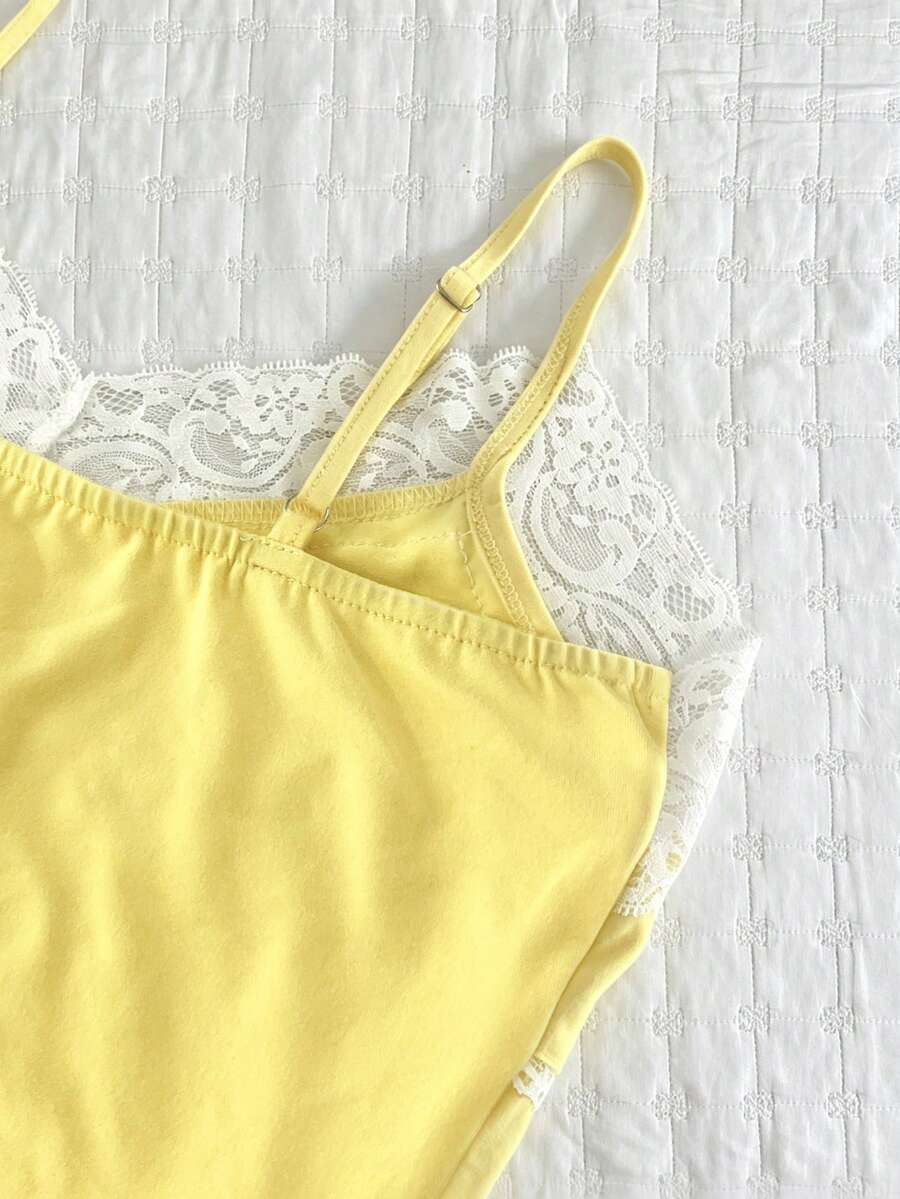 Women's solid color slim fit camisole top featuring delicate lace patchwork embroidery and tank straps.