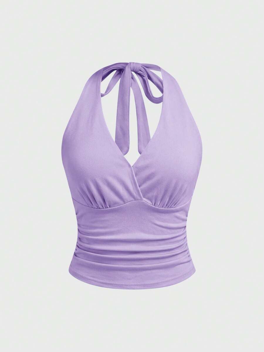 Women's halter crop tank top featuring a backless silhouette and ruched detailing in a slim fit design.