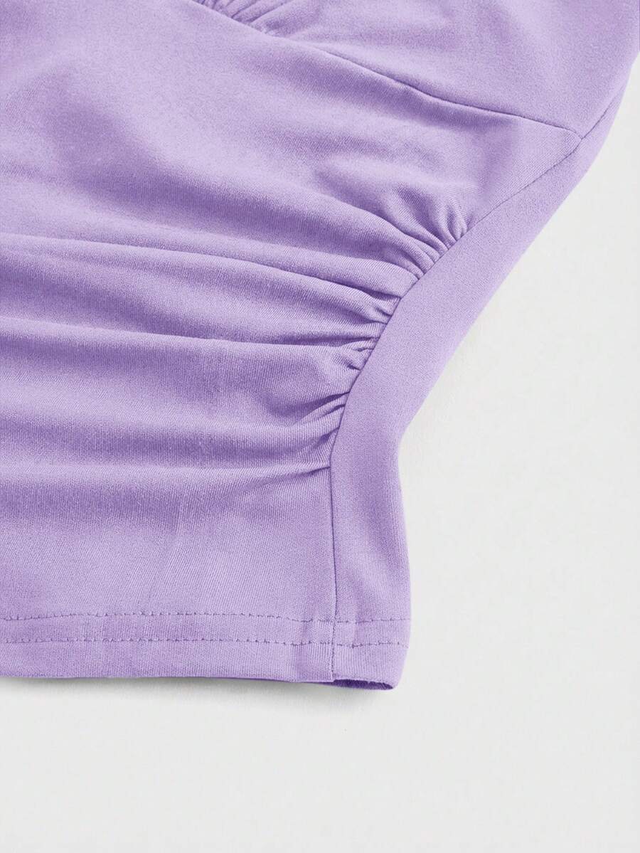 Women's halter crop tank top featuring a backless silhouette and ruched detailing in a slim fit design.