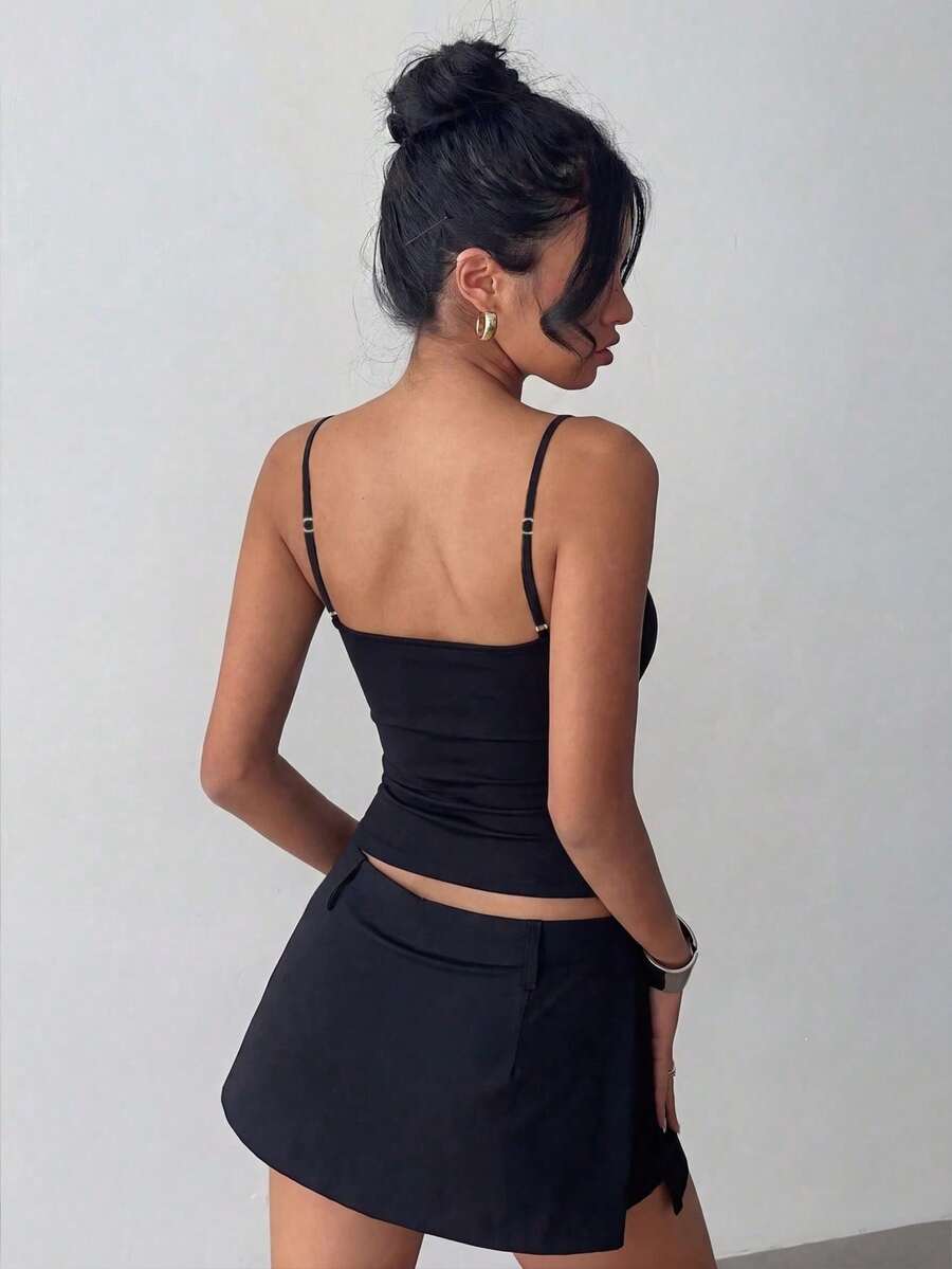 Women's black knitted cami top with spaghetti straps, asymmetrical detail, regular fit, and medium stretch for casual wear and vacation styling.