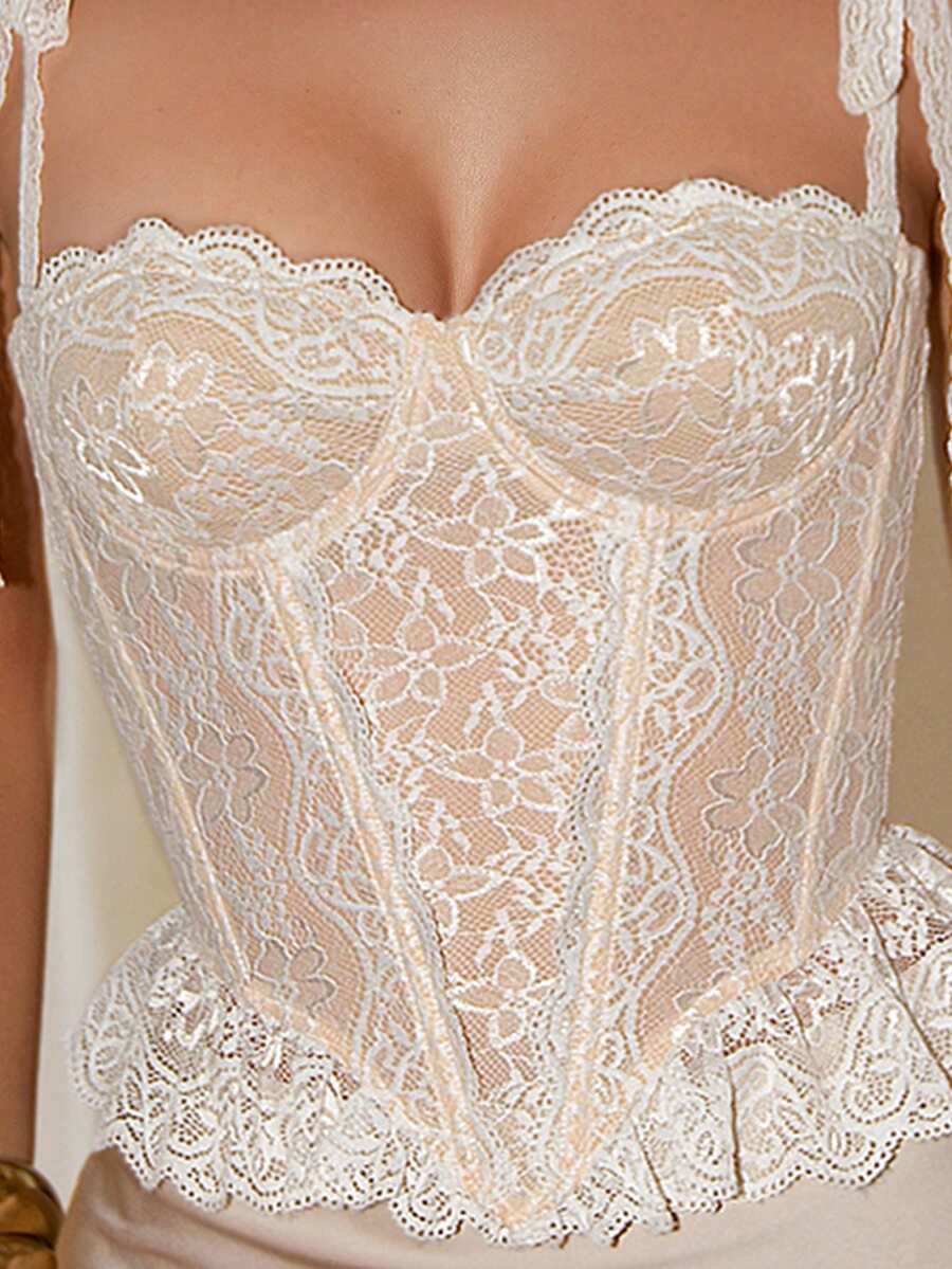 Women's lace camisole top featuring a boned bodice, sweetheart neckline, wide straps, and an asymmetrical crop hem.