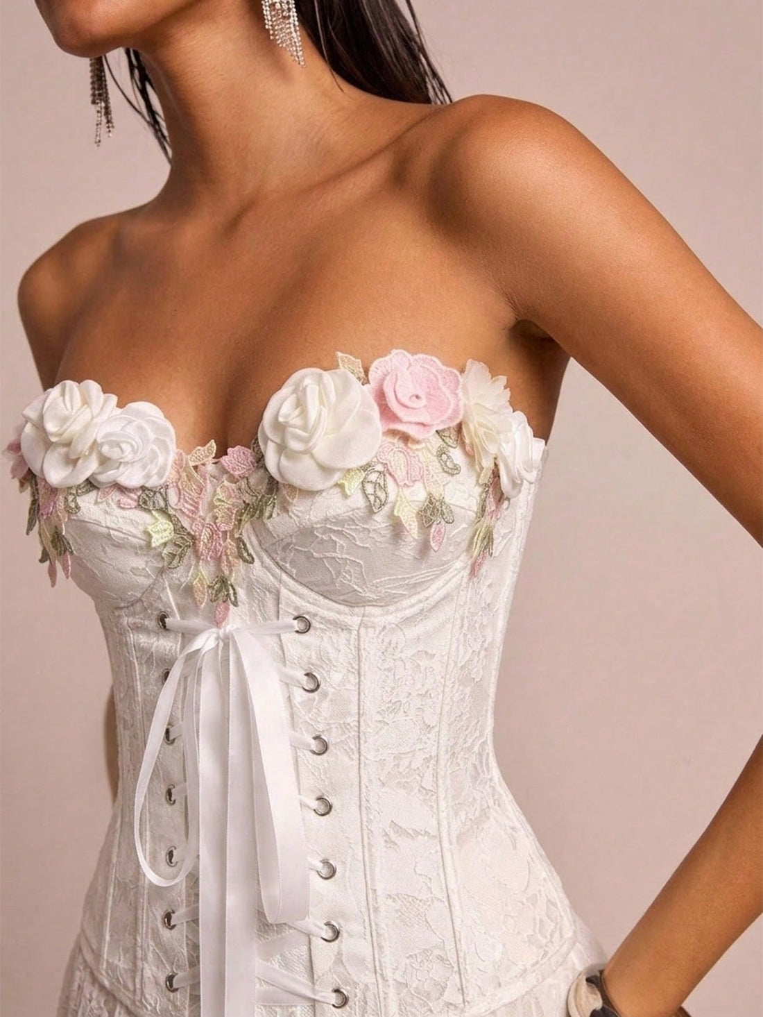 Women's beige strapless corset crop top featuring 3D rose floral decorations, an asymmetrical hem, and a slim fit lined design.