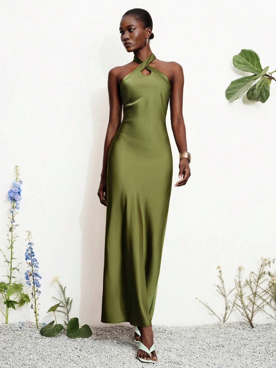 Women's black satin halter neck bodycon midi dress featuring a sleeveless backless design with front slit hem and wrap details.