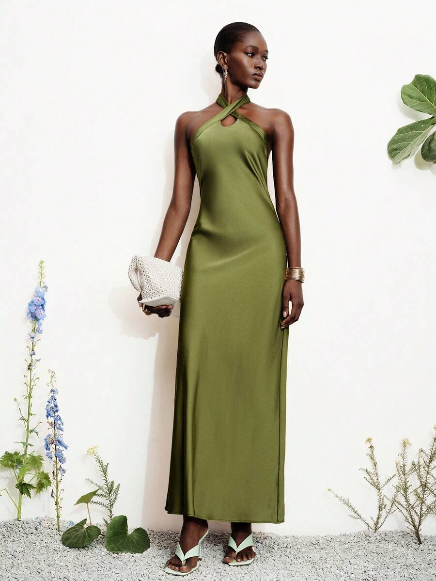 Women's black satin halter neck bodycon midi dress featuring a sleeveless backless design with front slit hem and wrap details.