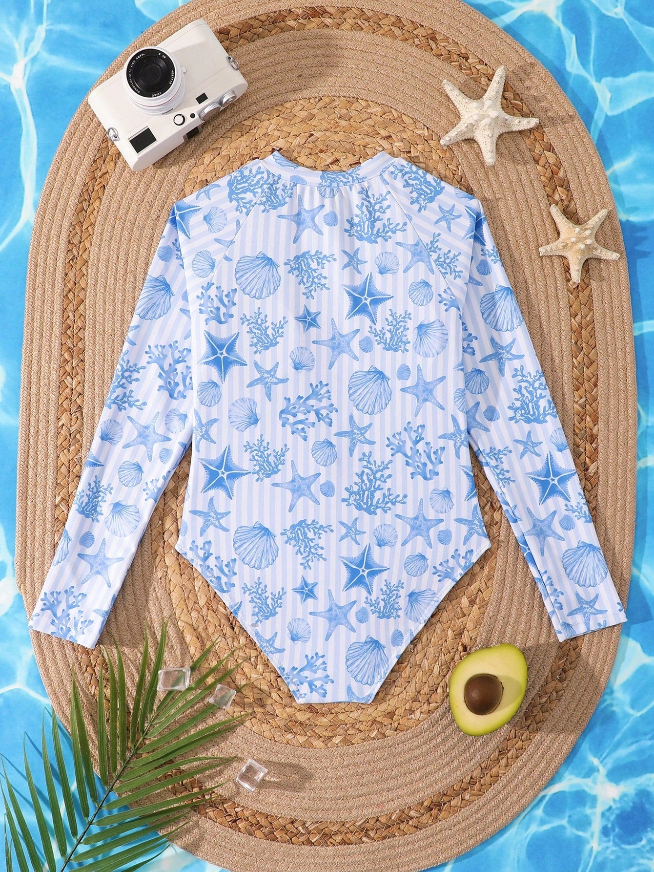 Tween girls one-piece rash guard swimsuit with long sleeves, high neck, front zipper, and ocean shell graphic print in a fitted style for beach, swimming, and vacation wear.