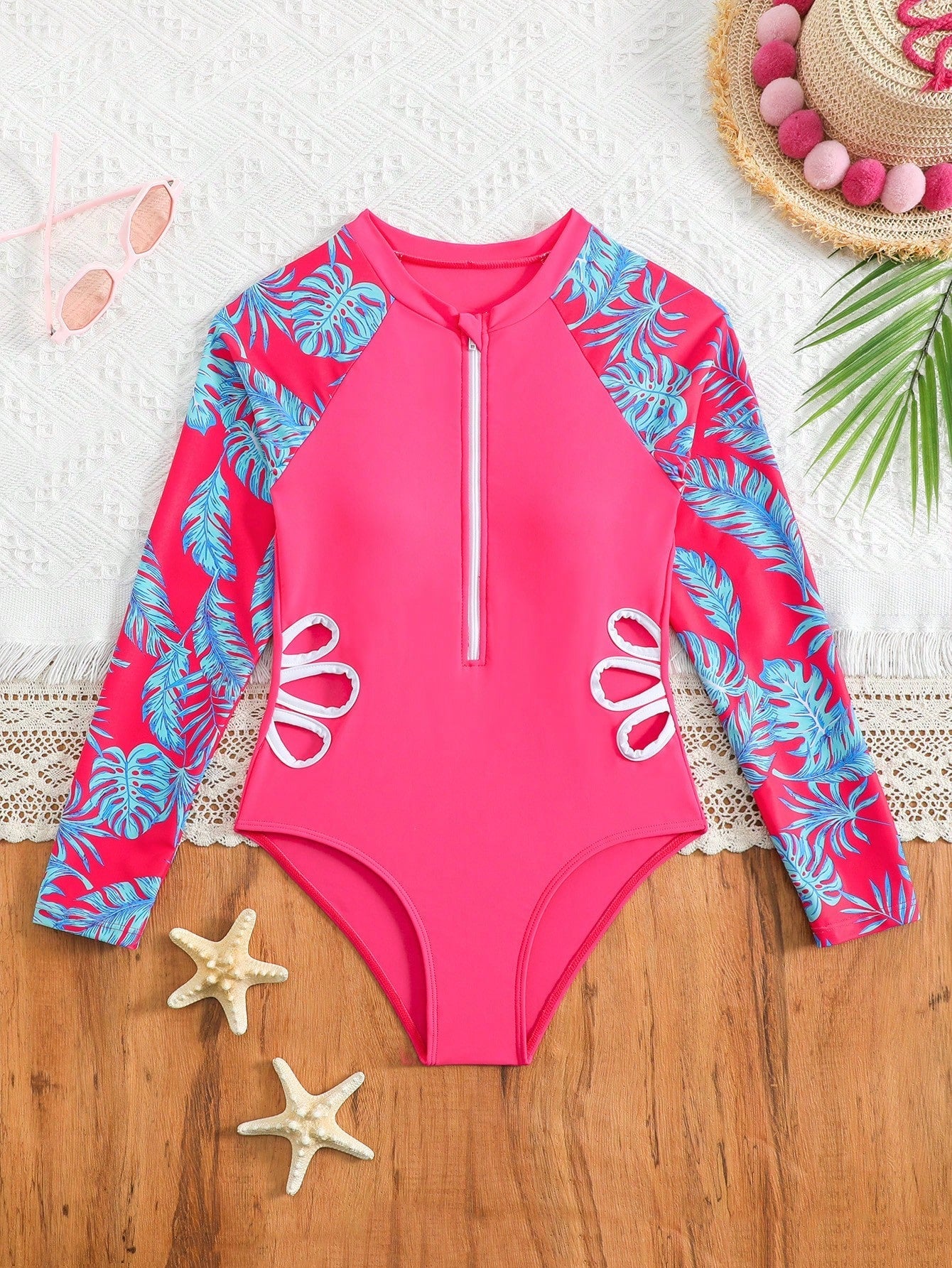 Tween girls one-piece rash guard swimsuit with long sleeves, high neck, front zipper, and ocean shell graphic print in a fitted style for beach, swimming, and vacation wear.