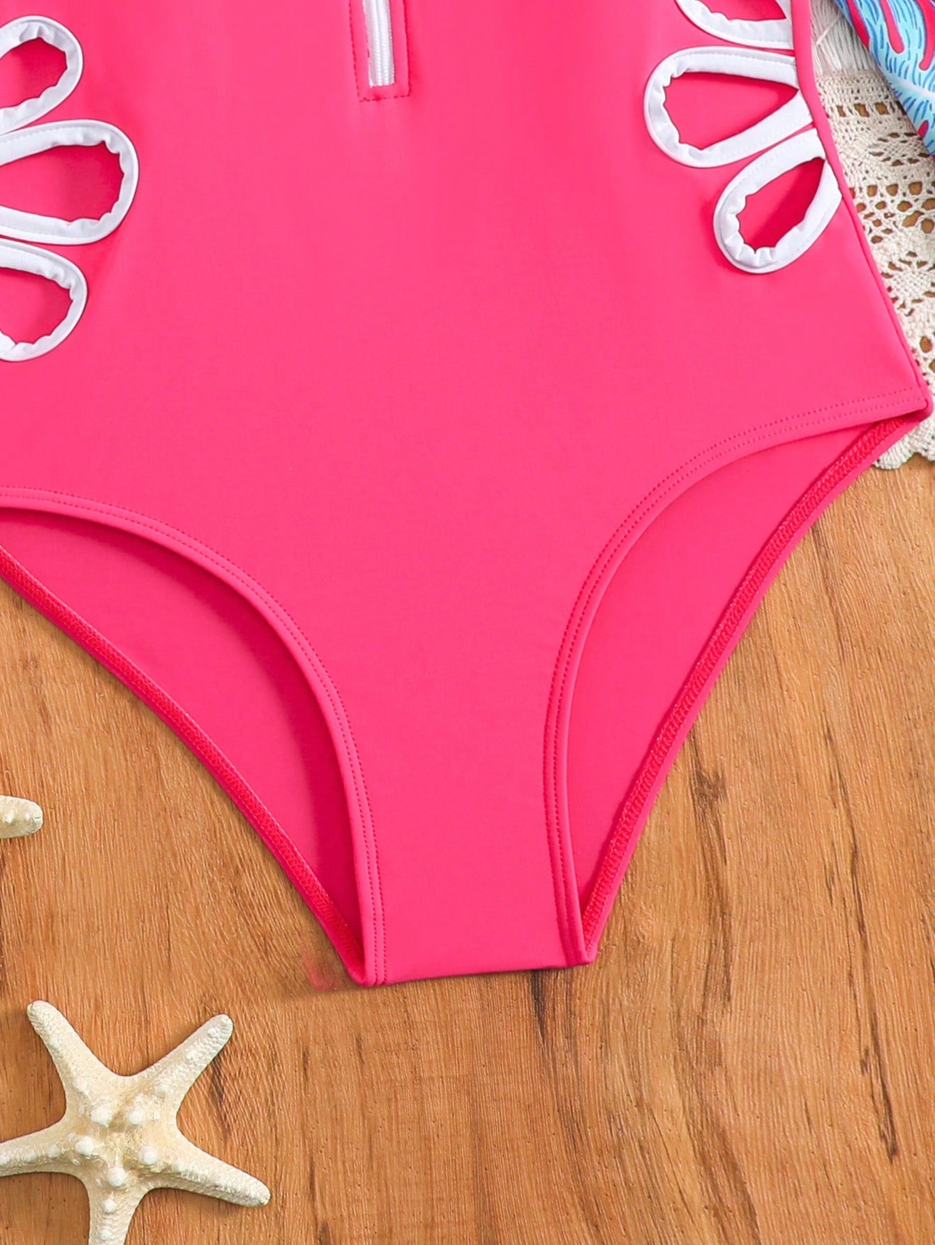 Tween girls one-piece rash guard swimsuit with long sleeves, high neck, front zipper, and ocean shell graphic print in a fitted style for beach, swimming, and vacation wear.