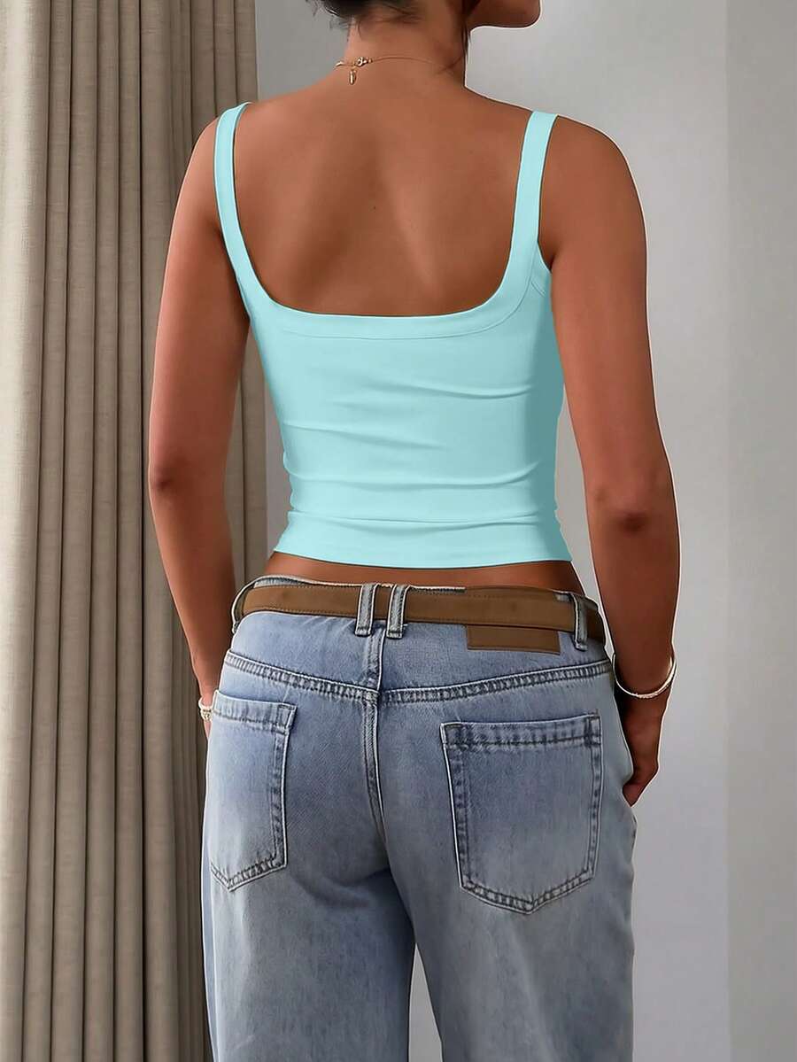 A slim fit women's crop cami tank top with spaghetti straps and a solid color design, made from comfortable stretch knitted fabric.