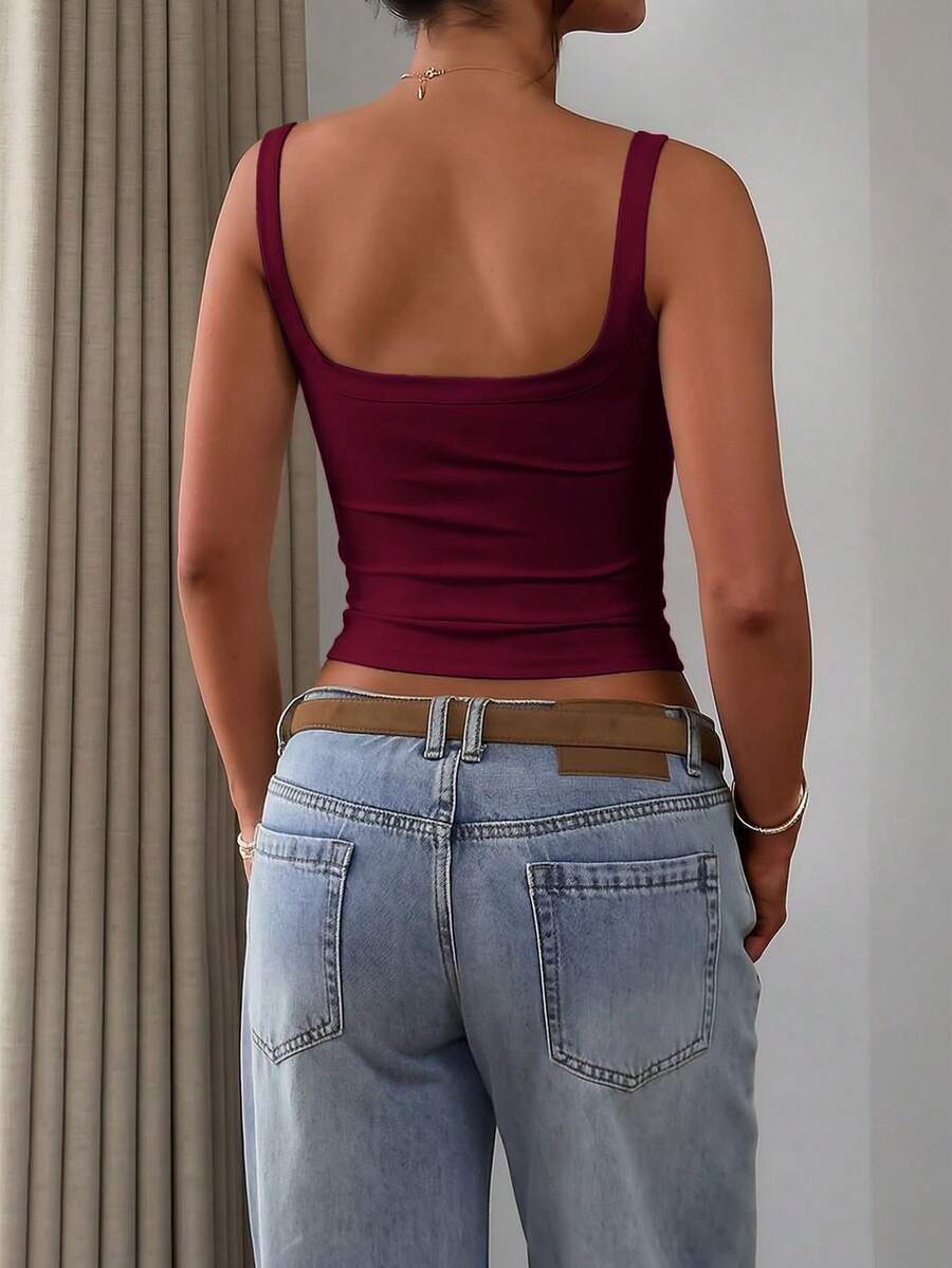 A slim fit women's crop cami tank top with spaghetti straps and a solid color design, made from comfortable stretch knitted fabric.