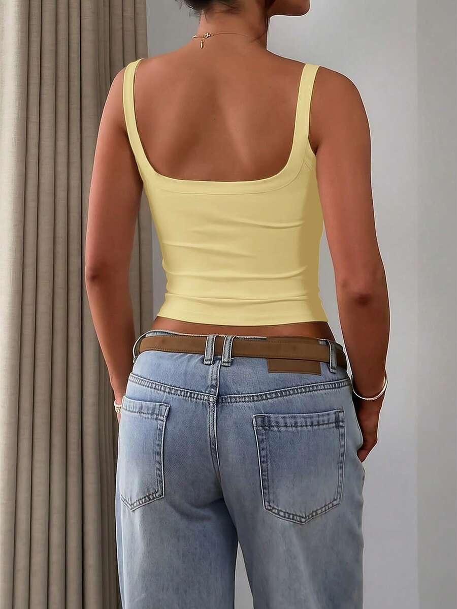 A slim fit women's crop cami tank top with spaghetti straps and a solid color design, made from comfortable stretch knitted fabric.