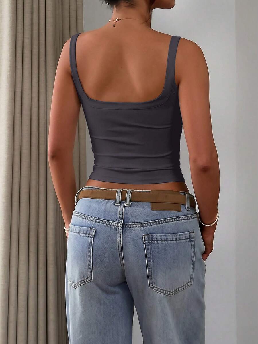 A slim fit women's crop cami tank top with spaghetti straps and a solid color design, made from comfortable stretch knitted fabric.