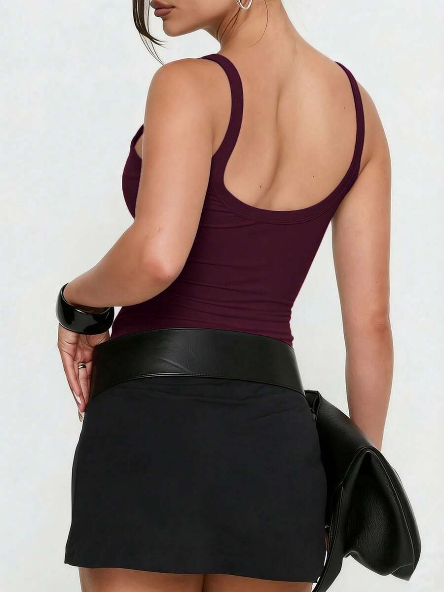 A slim fit women's crop cami tank top with spaghetti straps and a solid color design, made from comfortable stretch knitted fabric.