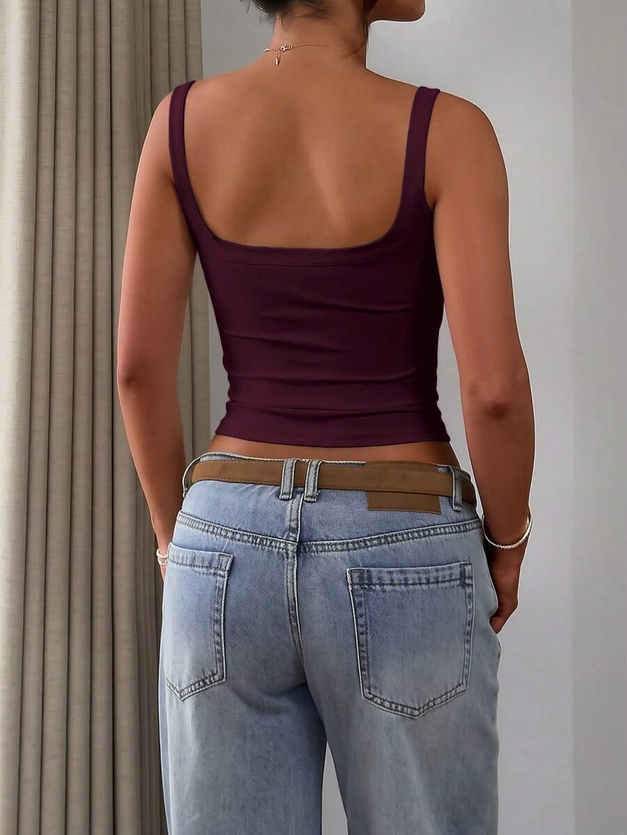 A slim fit women's crop cami tank top with spaghetti straps and a solid color design, made from comfortable stretch knitted fabric.