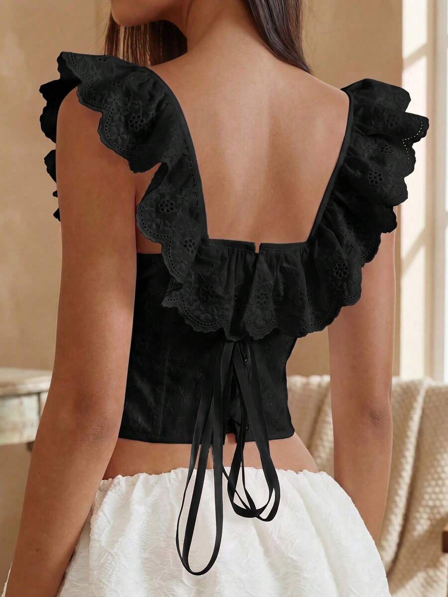 Women’s white corset top with embroidered ruffle trim, off-shoulder neckline, lace-up details, front hook closure, and sleeveless crop fit.