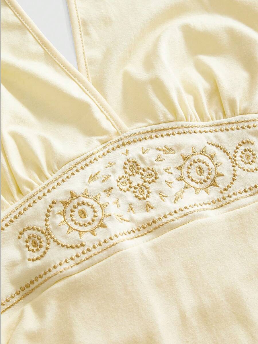 Women's sun totem embroidered sleeveless layered mini dress featuring a halter neck, backless tie back design, and slim fit high-waist A-line silhouette.