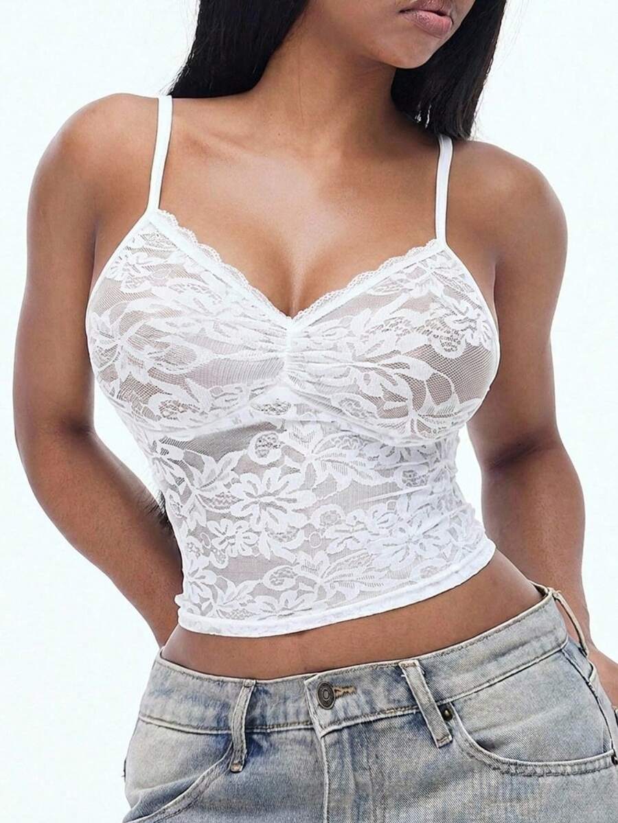 Women's black lace cami crop top featuring spaghetti straps, semi-sheer plant pattern fabric, and a backless design.