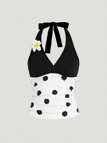 Black and white polka dot halter neck tank top featuring a backless design with ruched knot details and daisy accent.