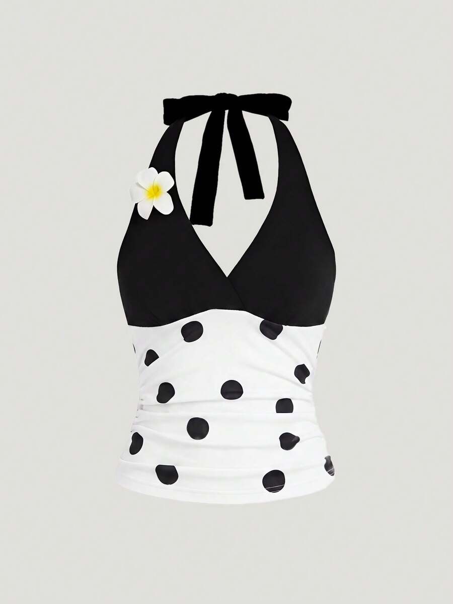 Black and white polka dot halter neck tank top featuring a backless design with ruched knot details and daisy accent.