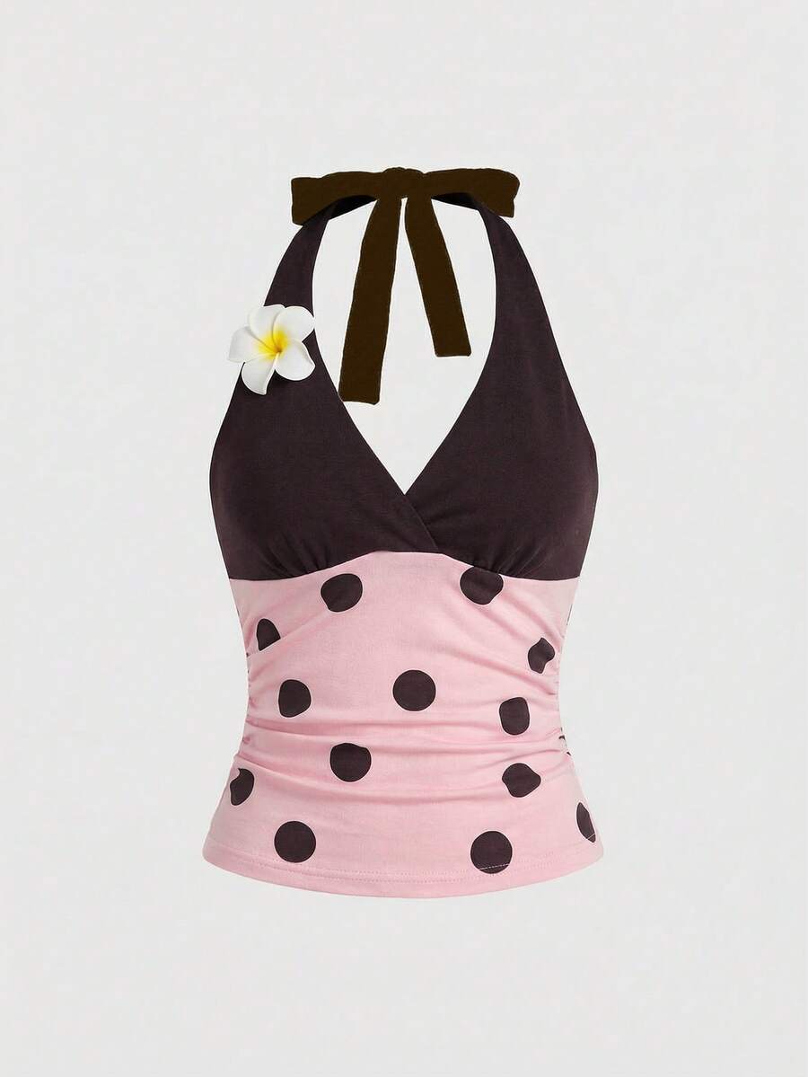 Black and white polka dot halter neck tank top featuring a backless design with ruched knot details and daisy accent.