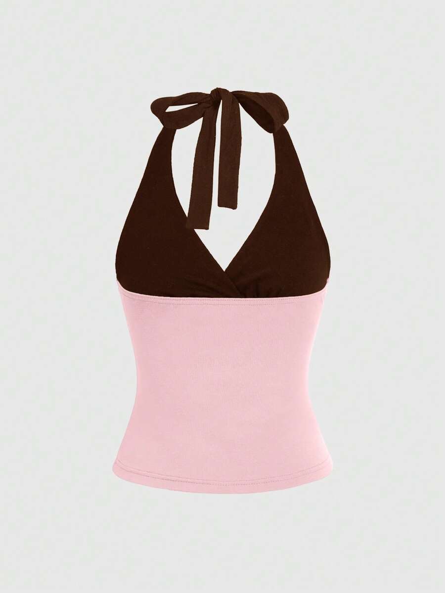 Black and white polka dot halter neck tank top featuring a backless design with ruched knot details and daisy accent.