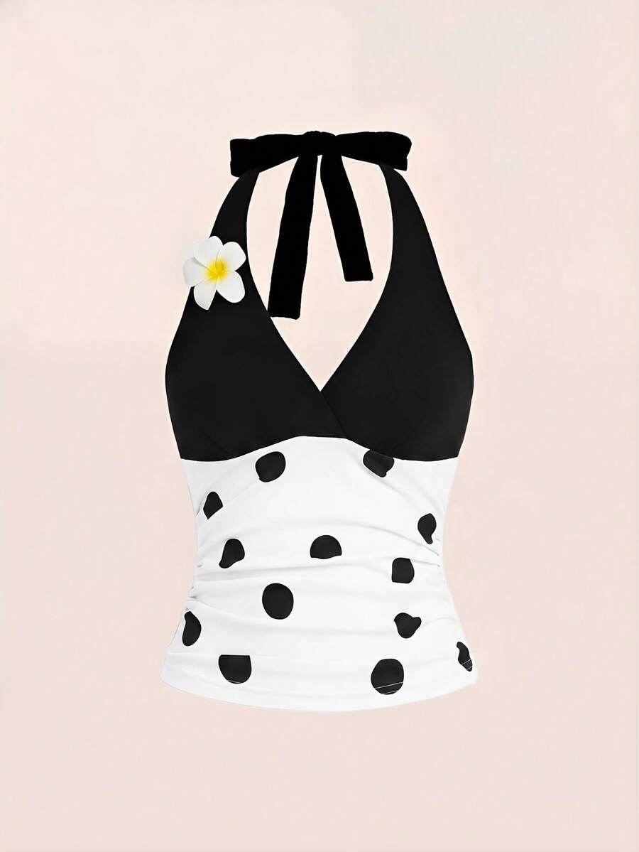Black and white polka dot halter neck tank top featuring a backless design with ruched knot details and daisy accent.