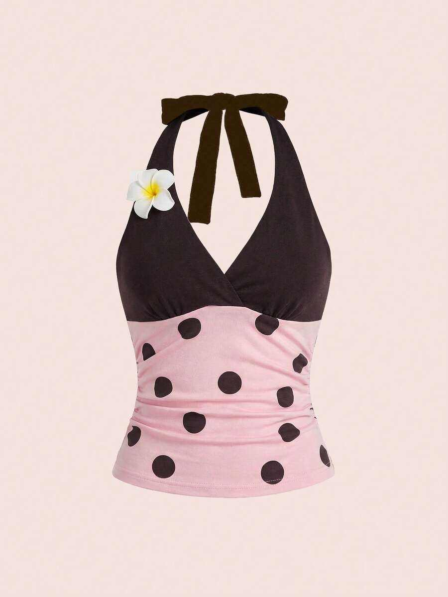 Black and white polka dot halter neck tank top featuring a backless design with ruched knot details and daisy accent.