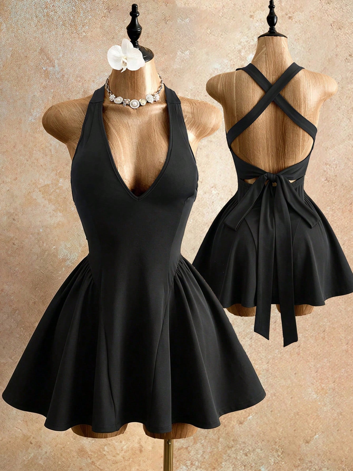 Sleeveless black halter mini dress for women featuring a high waist, A-line flared hem, and criss cross details.