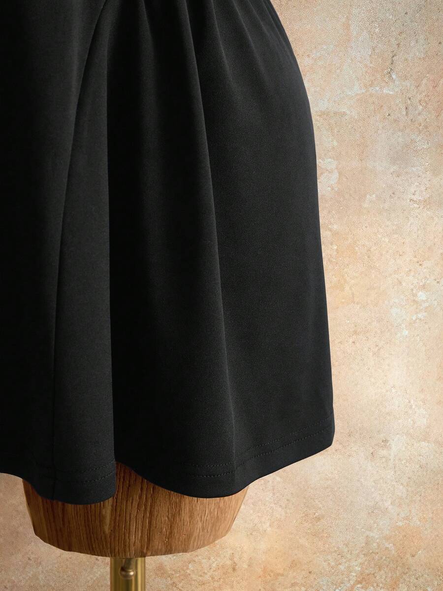 Sleeveless black halter mini dress for women featuring a high waist, A-line flared hem, and criss cross details.