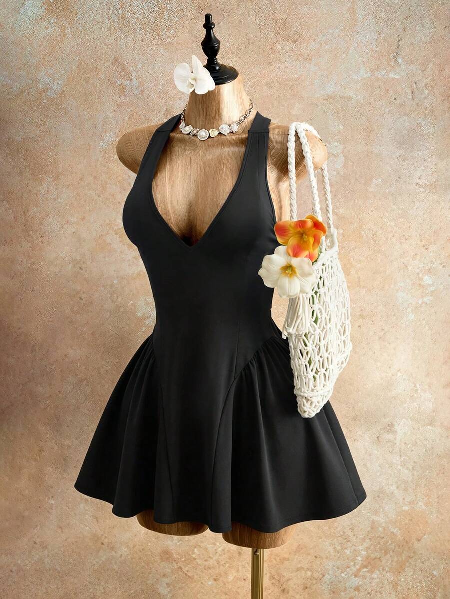 Sleeveless black halter mini dress for women featuring a high waist, A-line flared hem, and criss cross details.