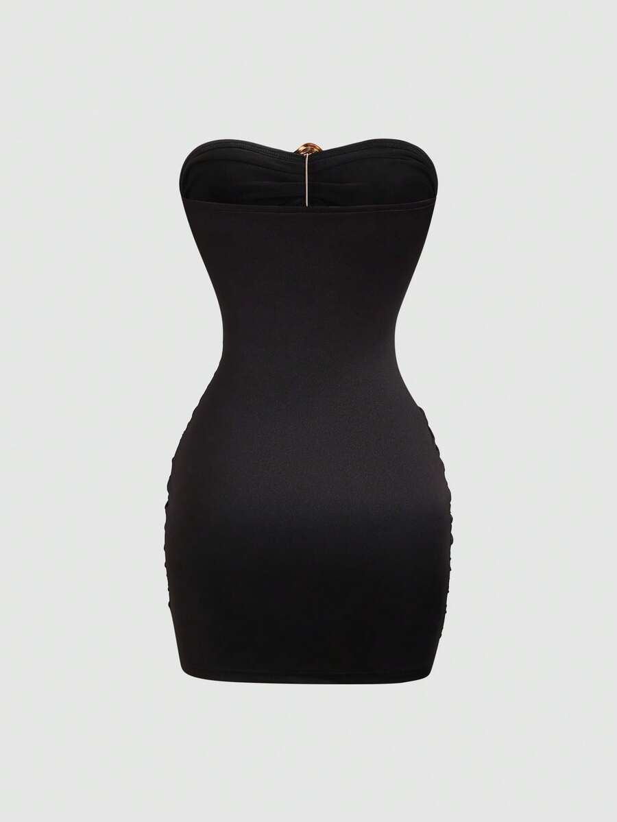 Women's black strapless bodycon mini dress featuring ruched detailing, cut-out design with ring accent, mid-waist pencil hem, and slim fit knitted stretch fabric.