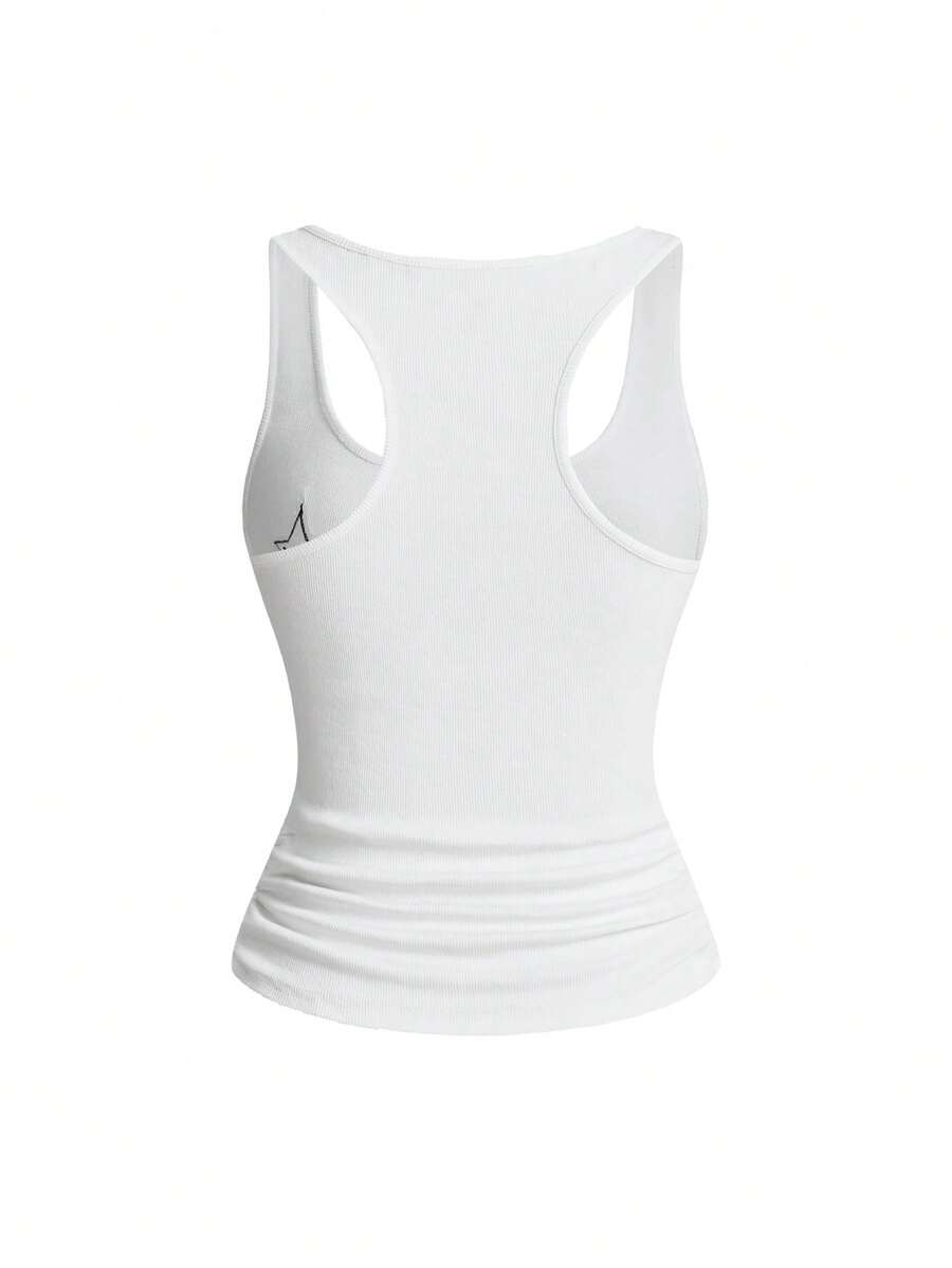 Women's white scoop neck camisole tank top featuring a badge patchwork print, front bow tie detail, cut-out accents, and slim-fit cotton stretch fabric.