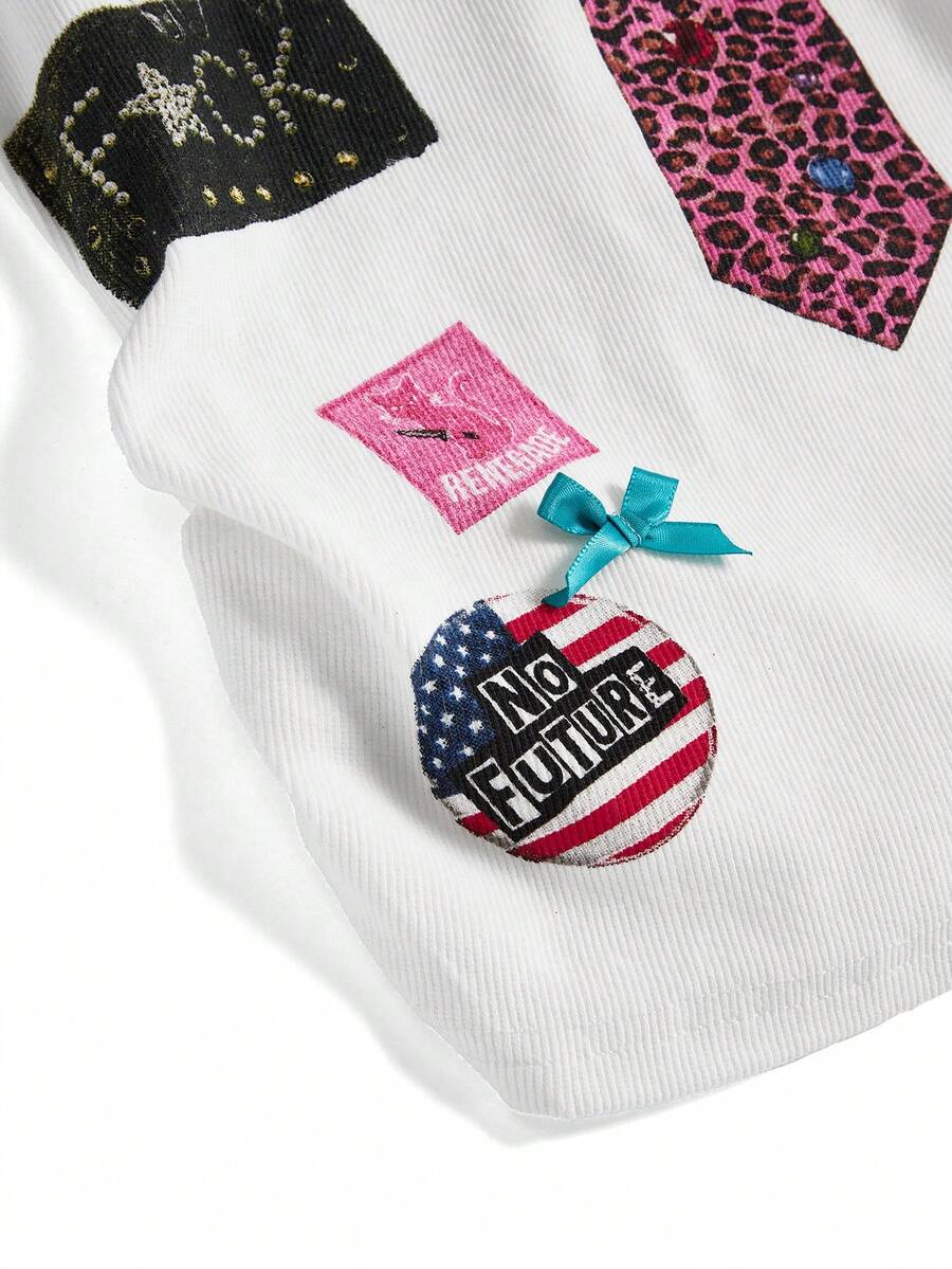 Women's white scoop neck camisole tank top featuring a badge patchwork print, front bow tie detail, cut-out accents, and slim-fit cotton stretch fabric.